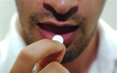 man takes a pill for stimulation